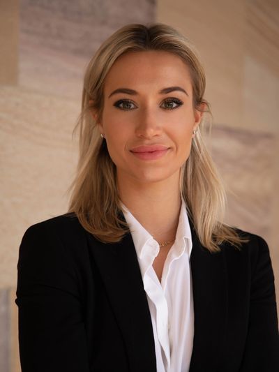 Professional woman in business attire smiling confidently.