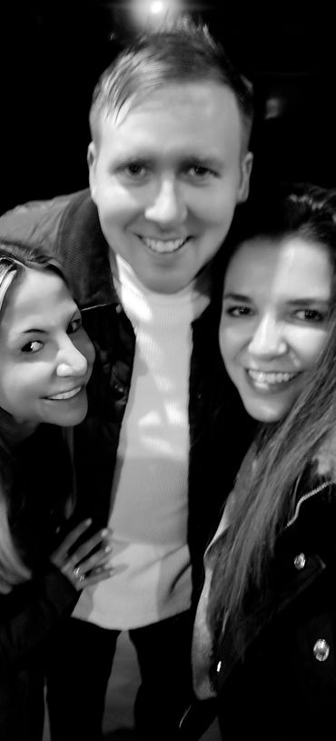 Three friends smiling closely together in a black and white photo.