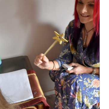 Woman with red hair holding a star wand, smiling.