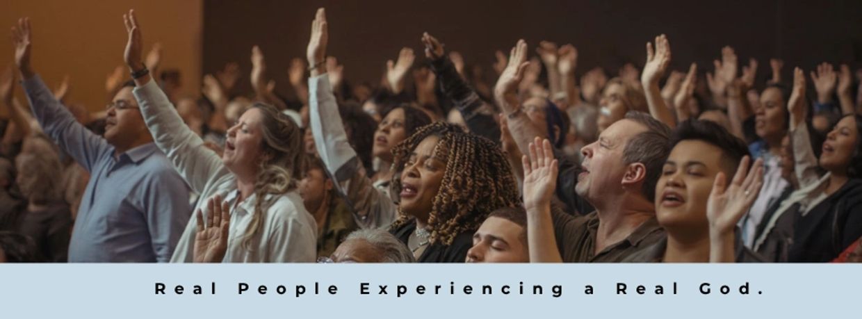 People worshipping together with raised hands in a church.