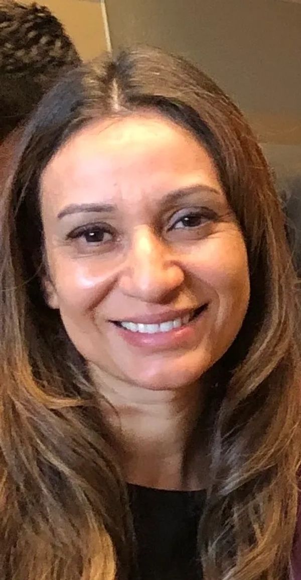 Smiling woman with long brown hair and natural makeup.