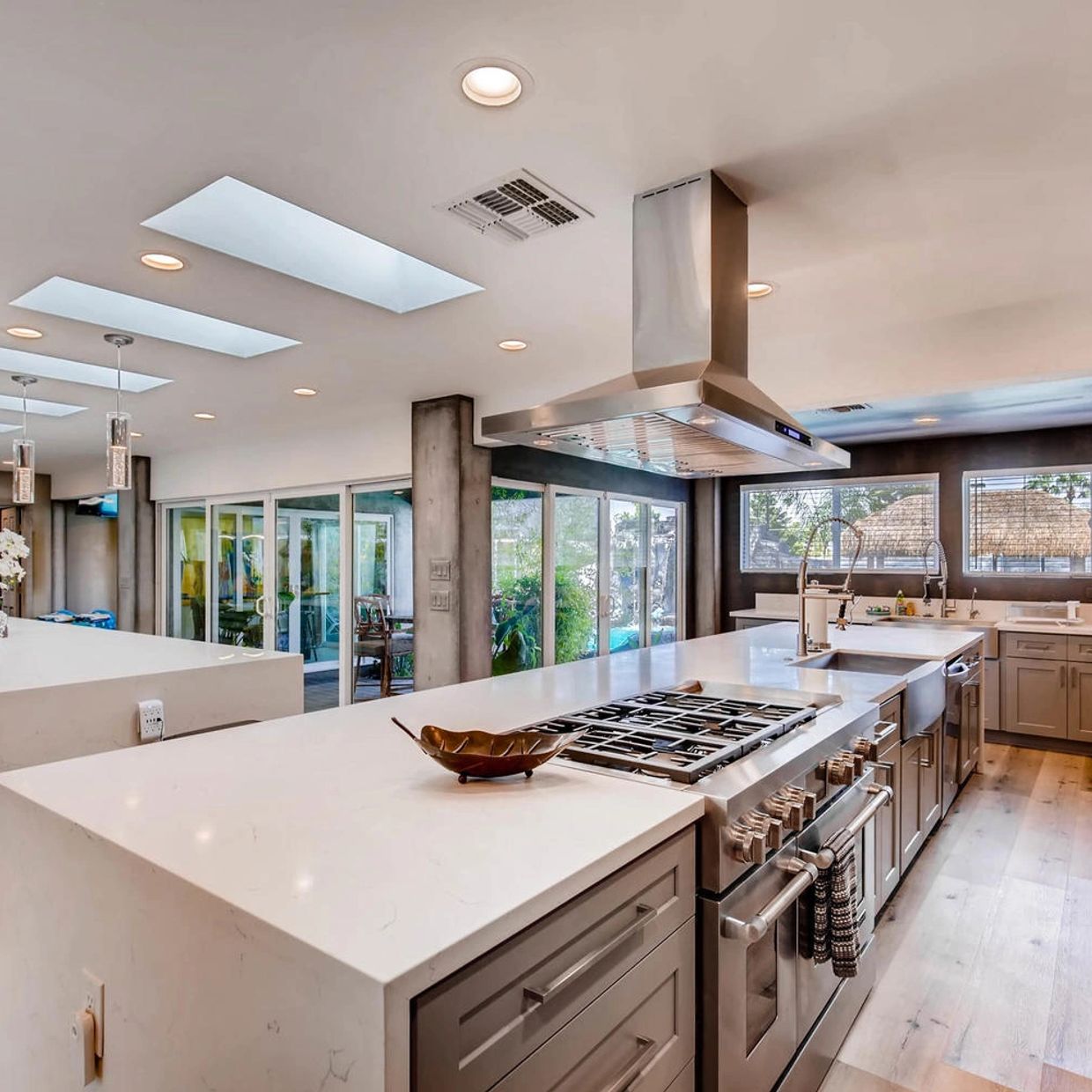 Spacious modern kitchen with large white countertops and skylights.