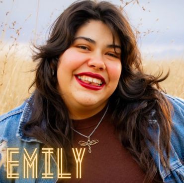 Happy woman named Emily smiling outdoors.