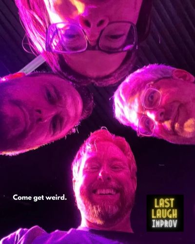 Four people looking down with purple lighting and 'Come get weird.' text.