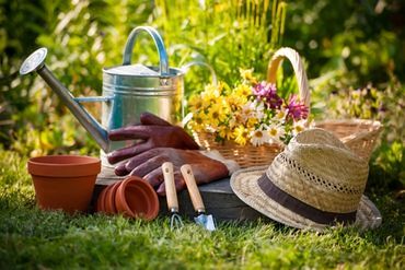 Garden tools and sun hat on grass