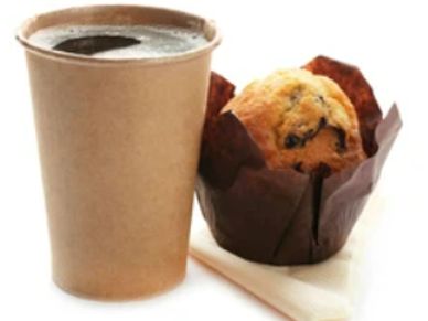 A cup of coffee and a blueberry muffin on a napkin.