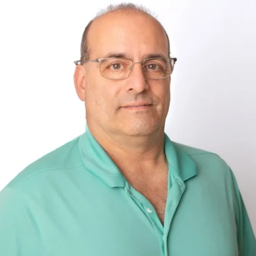 Man in teal polo shirt with glasses.