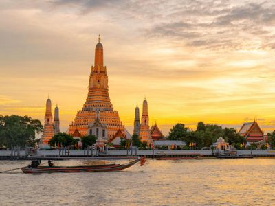 Wat Arun temple by the river at sunset in Bangkok, Thailand.