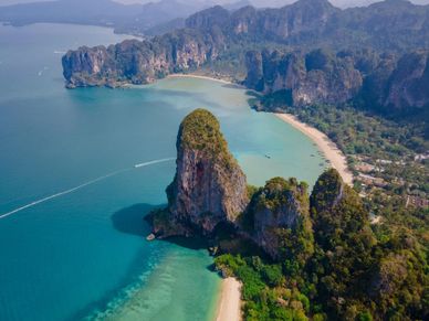 Aerial view of a tropical beach with limestone cliffs and turquoise water.