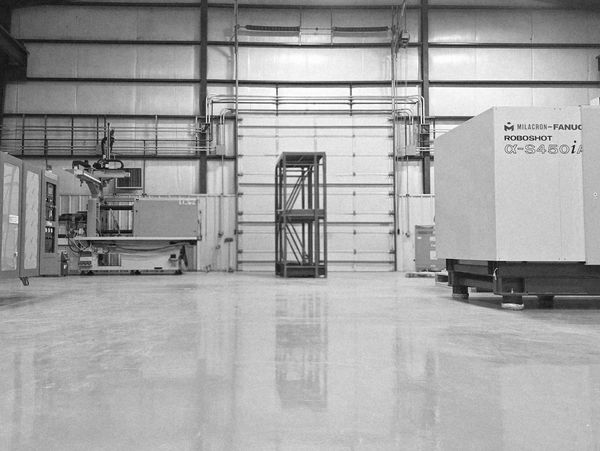 Industrial warehouse with large machinery and empty shelving.