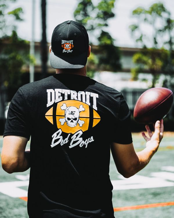 Man in Detroit Bad Boys shirt holding a football.