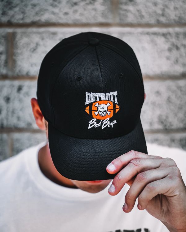 Person wearing a black 'Detroit Bad Boys' cap.