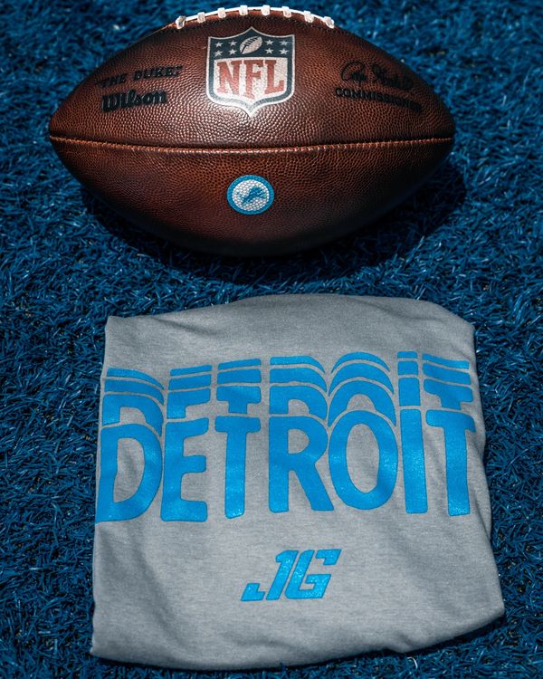 NFL football and Detroit shirt on blue turf.