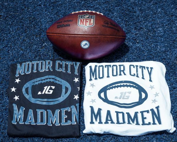 NFL football and two Motor City Madmen T-shirts on blue turf.