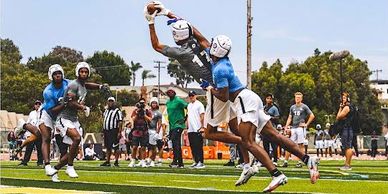 Athletes making an impressive catch in a football game.
