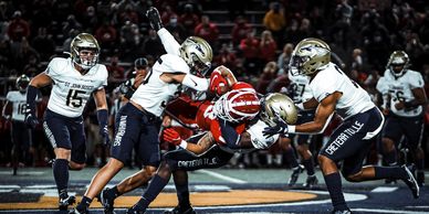 Football player tackled by opposing team.