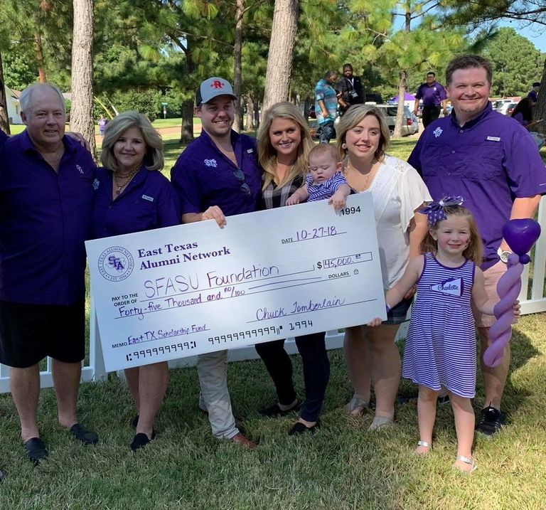 Tomberlain Insurance Family presents SFA  East Texas Alumni Scholarship check to University. 