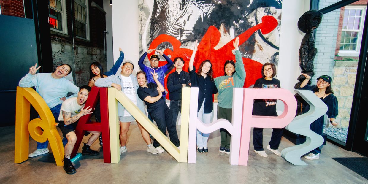 Group of friends posing happily with colorful letters spelling 'AANWPS'.