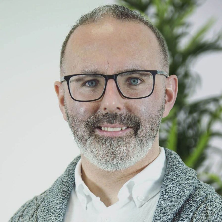 Photo of Steven O Riordan, Psychotherapist with a white shirt, glasses, a beard and a grey cardigan
