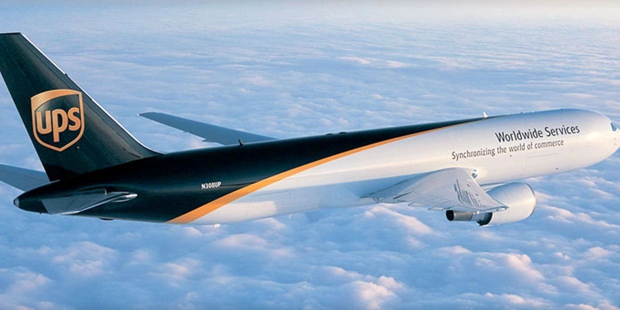 UPS cargo airplane flying above clouds.
