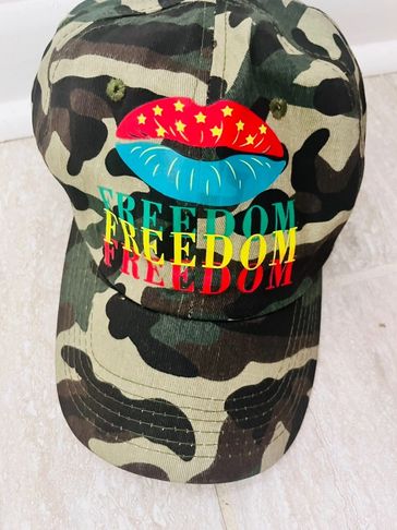 Camouflage cap with colorful lips and repeated 'FREEDOM' text.
