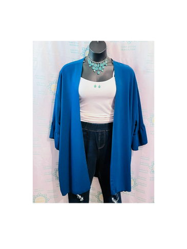 Blue open-front cardigan styled with a white tank top and dark jeans on a mannequin.