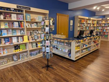 Cozy bookstore corner with books, cards, and a checkout counter.
