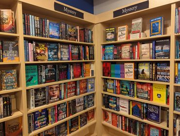 Bookshelves filled with mystery novels in a bookstore corner.