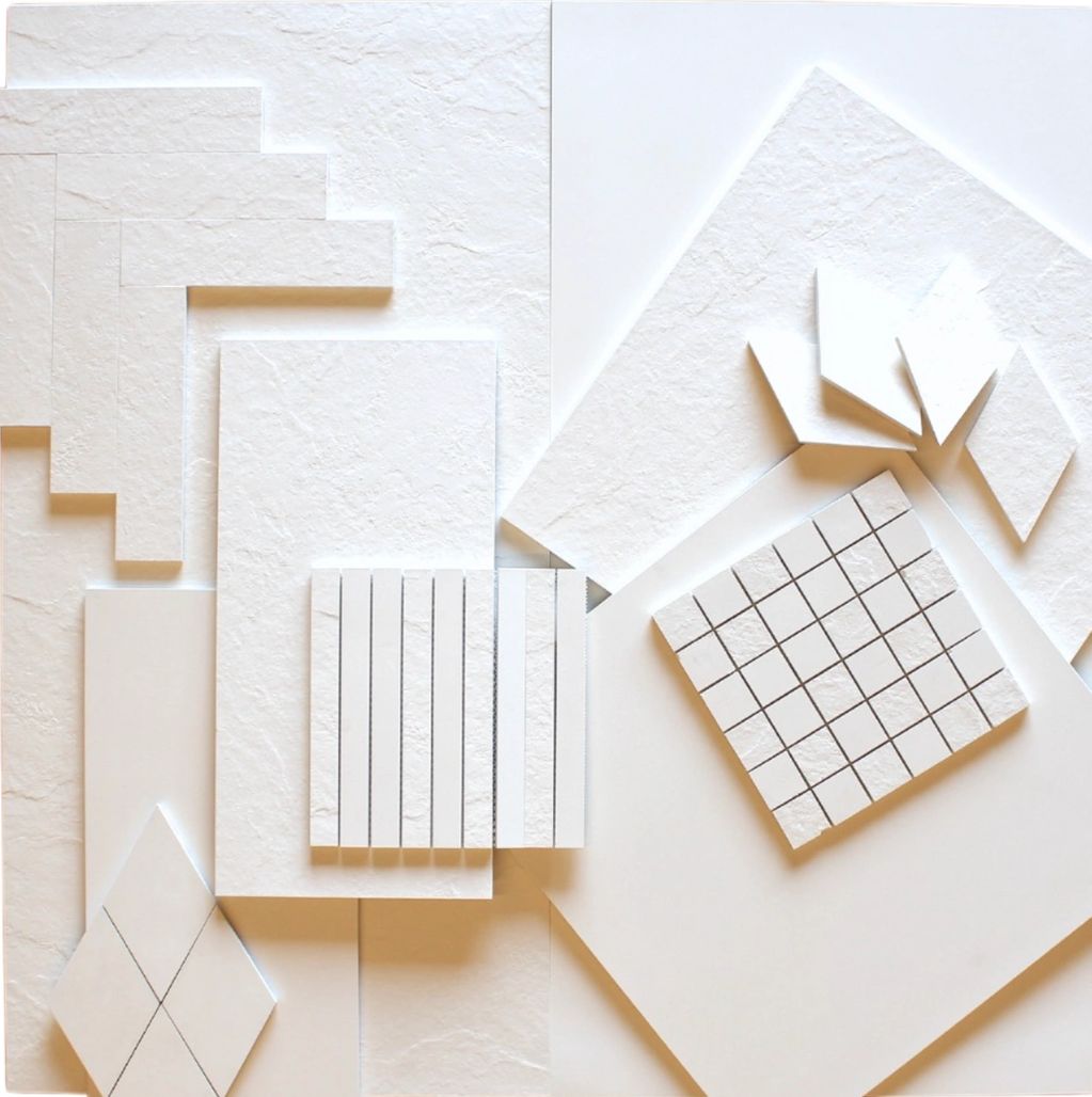 White paper shapes with different patterns on a flat surface.