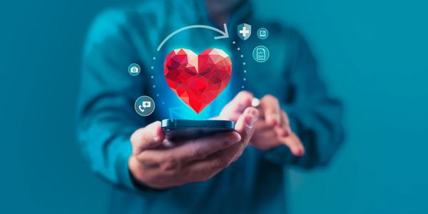 Person holding phone with digital heart and health icons floating above.