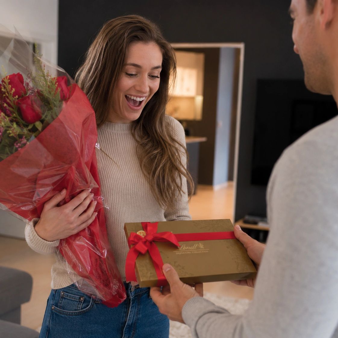 Woman happily receiving flowers and a gift box.