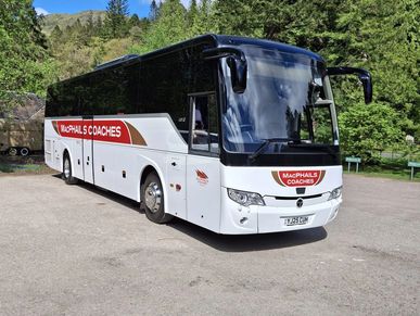 A white MacPhails Coaches tour bus parked on a sunny day.