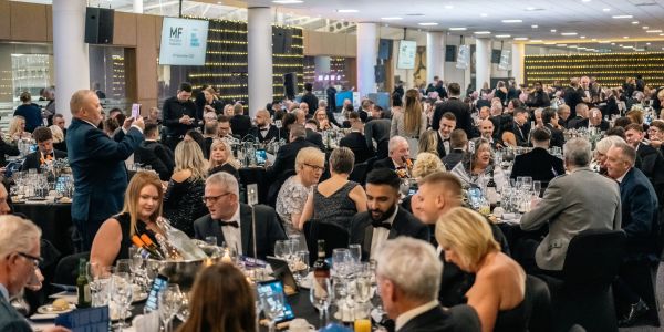 Elegant formal dinner event with many guests seated at tables.