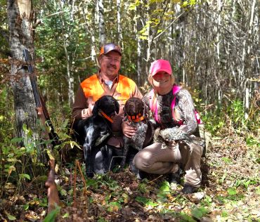 Two hunters with dogs in the forest.
