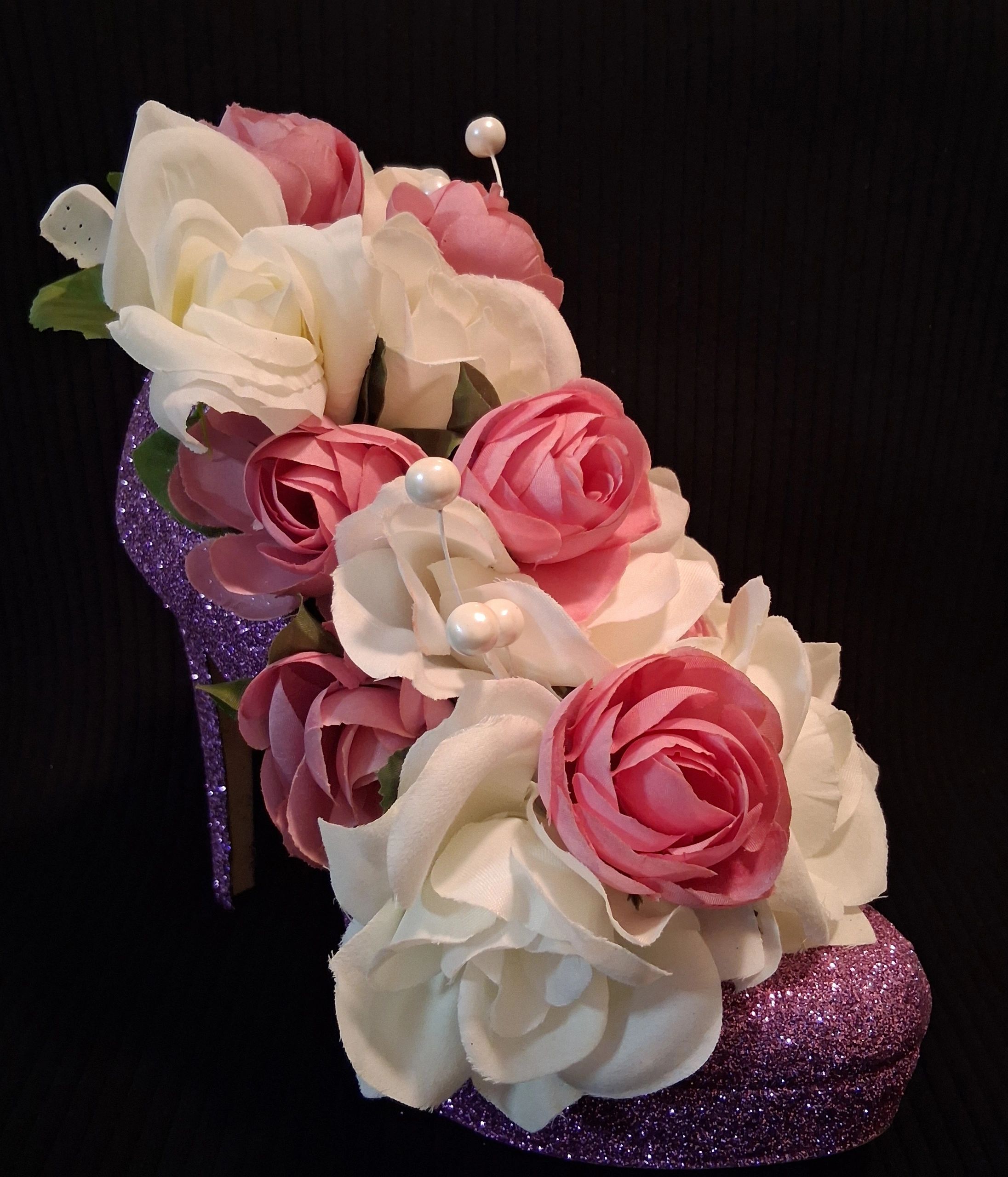 Pink and white artificial roses on a glittery purple high heel.