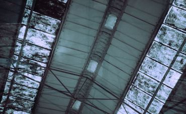 Industrial ceiling with light panels and metal beams.