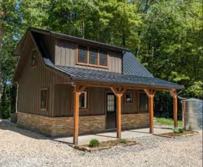 Small cozy cabin surrounded by trees.