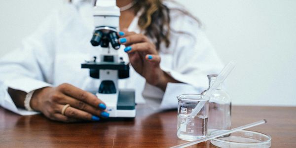 Scientist holding a microscope. artist pexels-anntarazevich