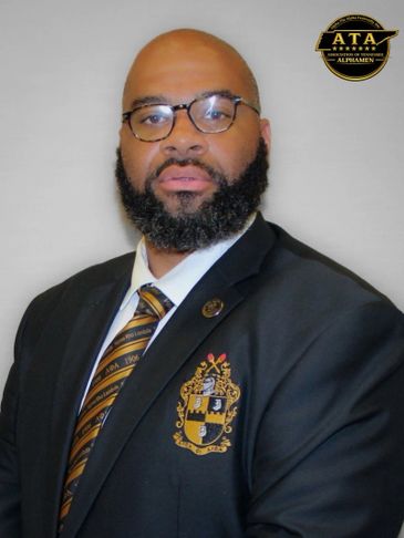 Professional man in a suit with a crest and ATA badge.