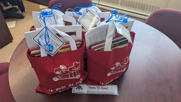 Red bags filled with gifts on a table.