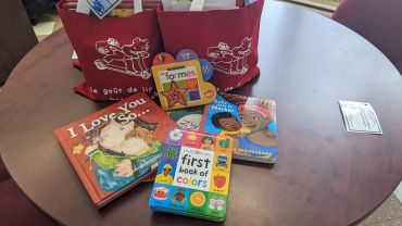 Children's books and toys on a round table.