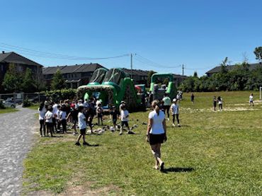 Children enjoying a sunny day with inflatable slides outdoors.