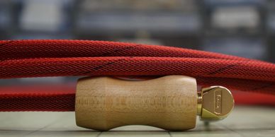 Close-up of a wooden-handled tool and red braided cord.