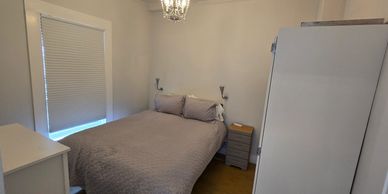 Apt 3 bedroom with bed, dresser, and wardrobe.