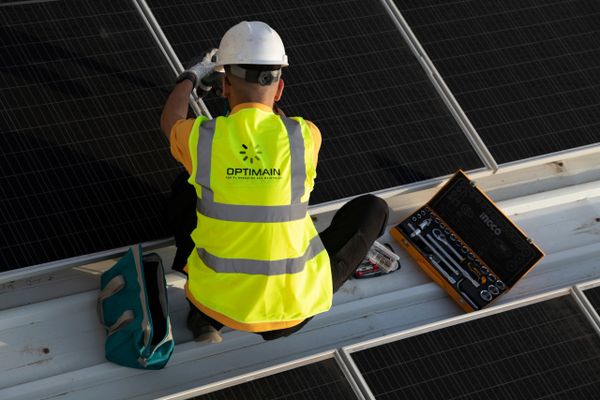 an electrical engineer with tools box is drilling solar panel