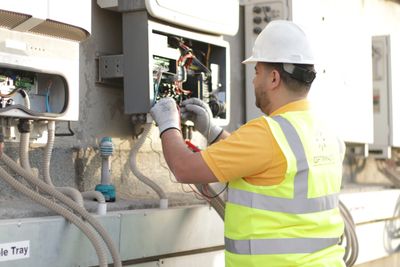 an electrical engineer is fixing wires in an inverter