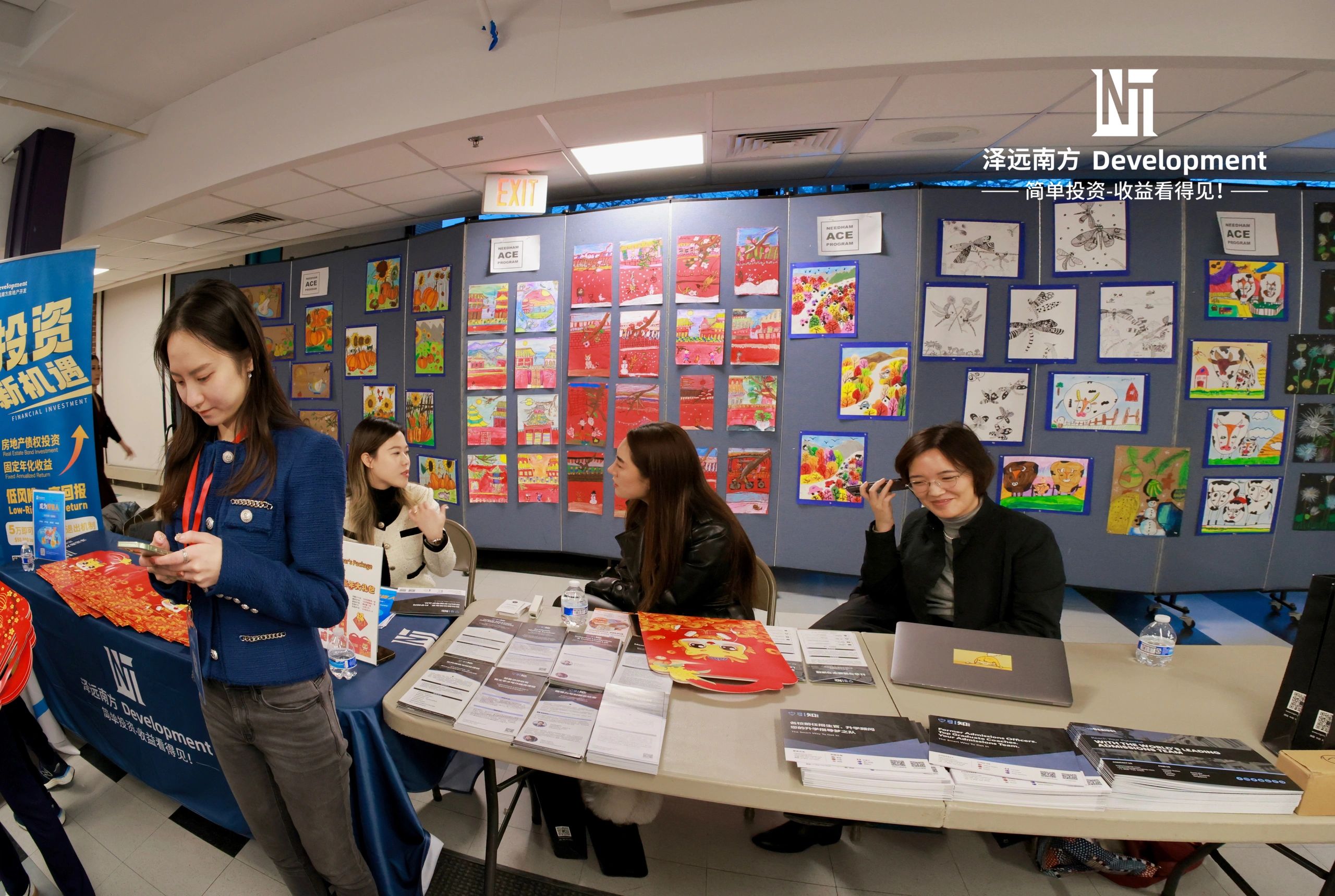 People at an indoor exhibition with colorful artwork and informational brochures.