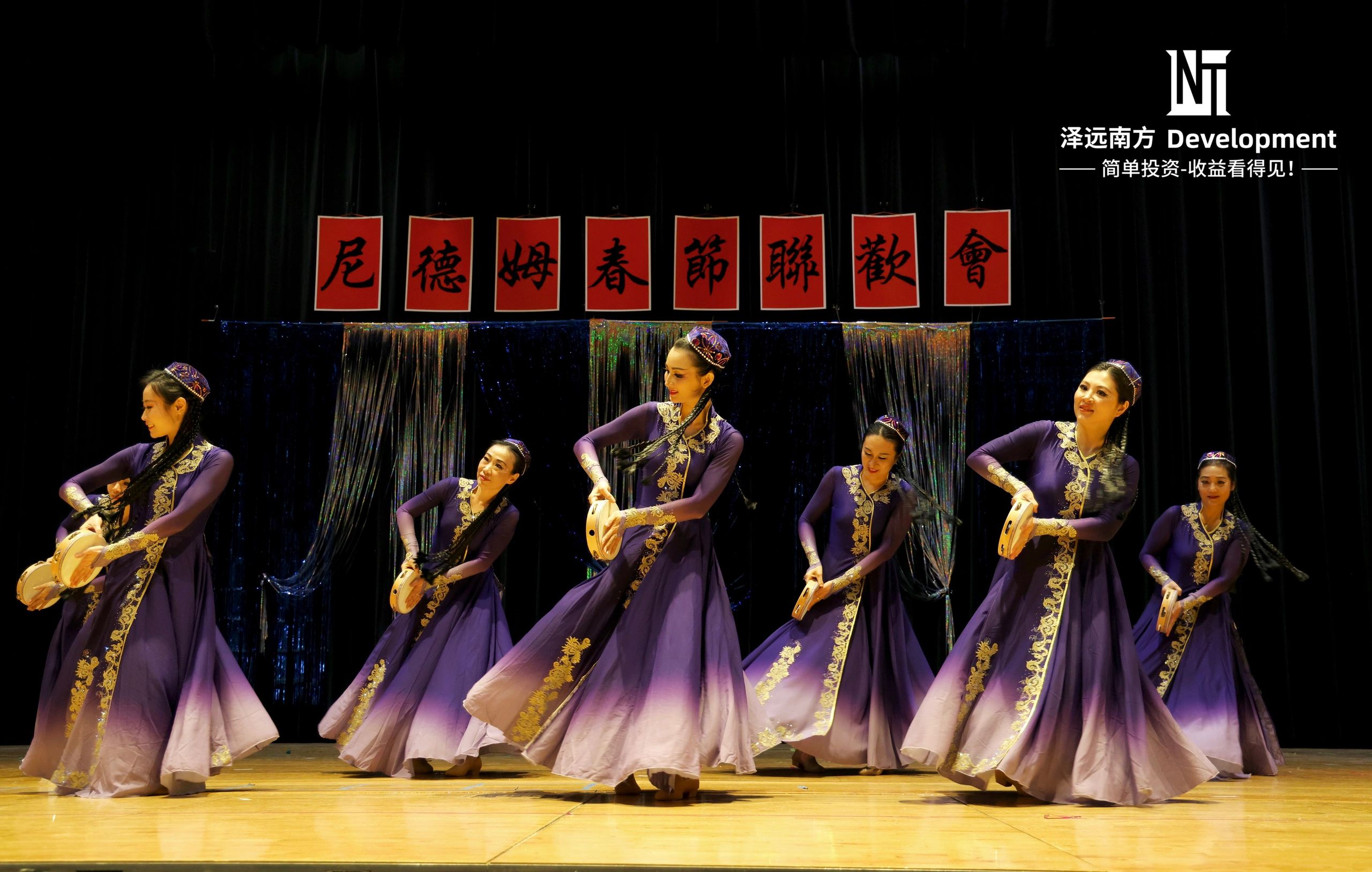 Group of dancers performing in purple traditional dresses.