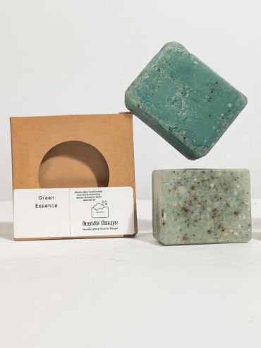 Two green homemade soaps with their packaging.