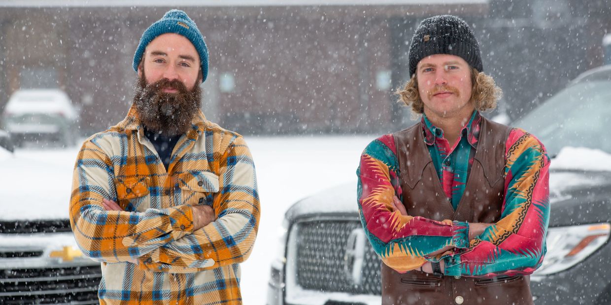 A to Z Owners Karl Rempe and Caleb Dvorak posing in front of company cars in Big Sky Town Center.